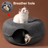 Cat sleeping in the tunnel of the felt donut bed